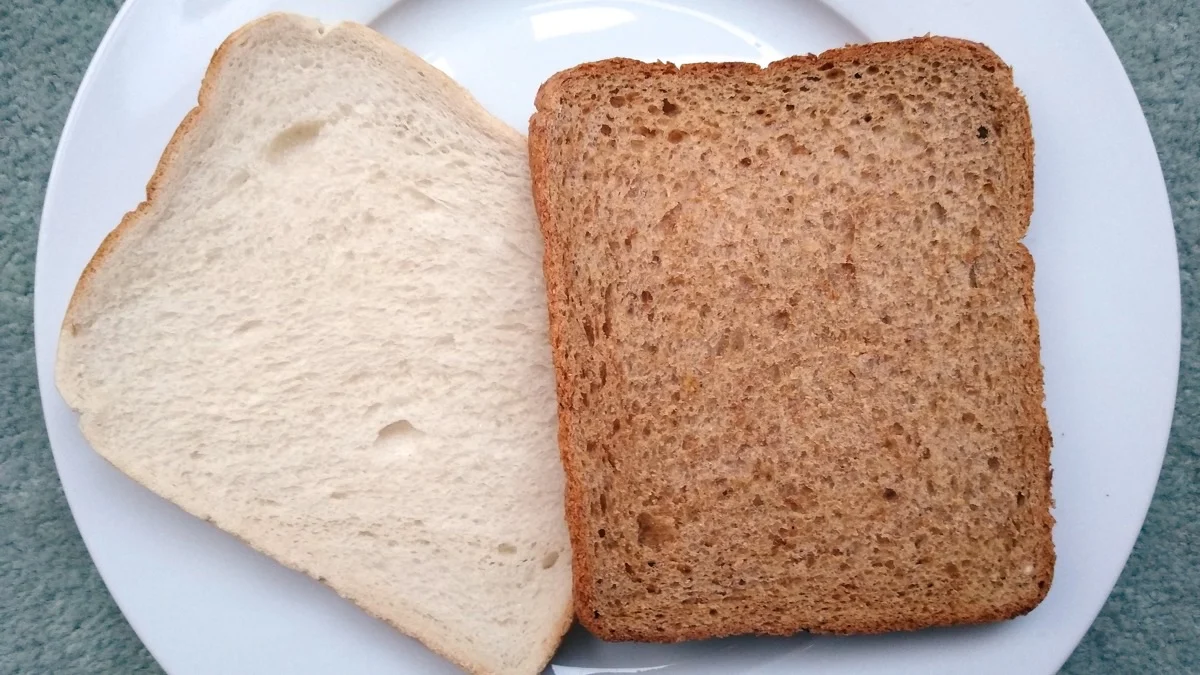 Square slices of soft white milk bread on a plate, showing a fine, even crumb
