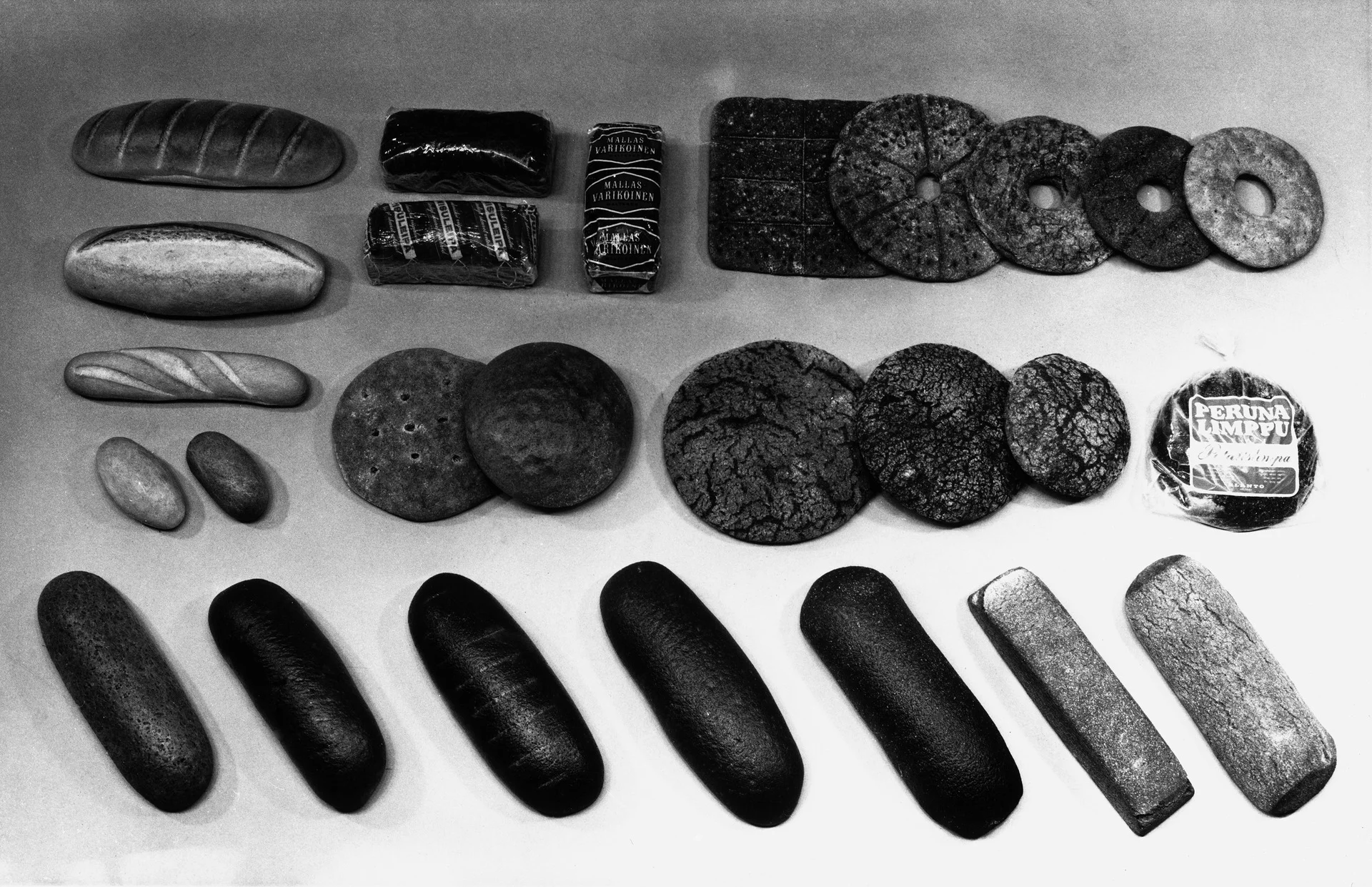 棚に並ぶフィンランドのパン。右列に穴あきリングパン（reikäleipä）が写る白黒写真