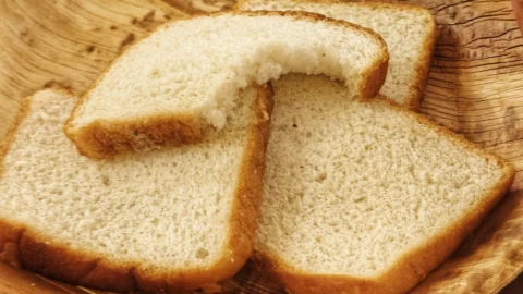木の皿に並んだ、きめの細かい白い食パンのスライス