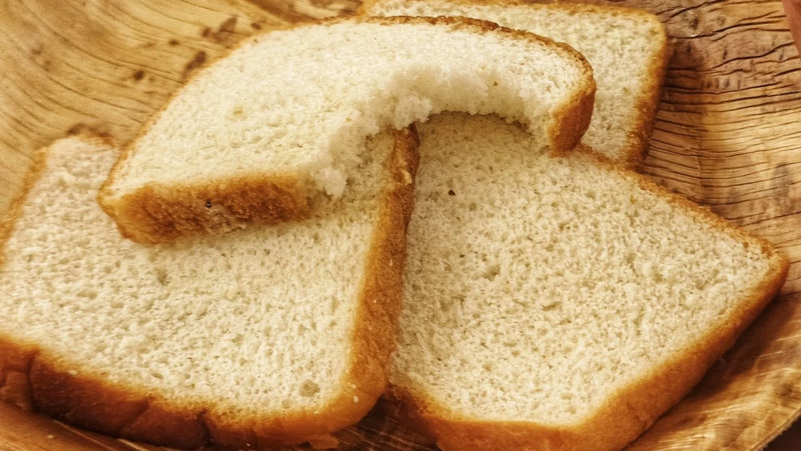 木の皿に並んだ、きめの細かい白い食パンのスライス